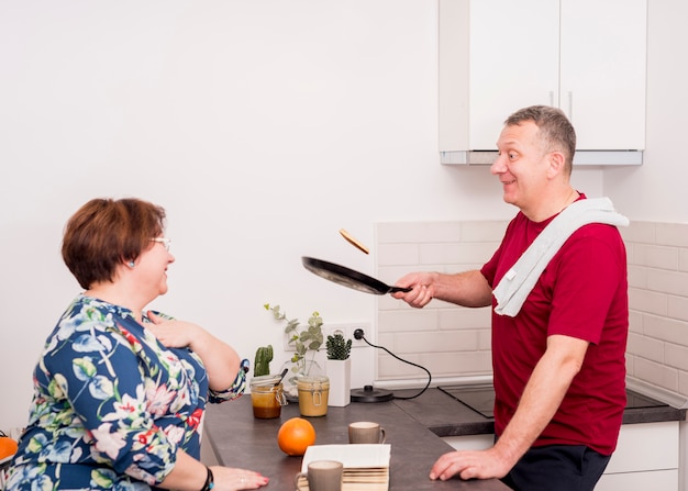 Free photo elderly couple cooking pancakes