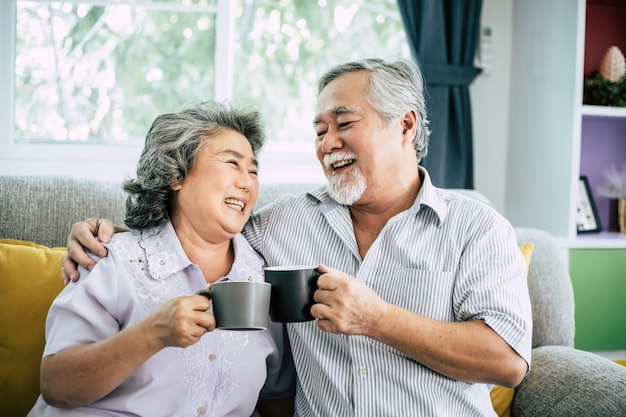 Elderly Couple Talking together and drinking coffee or milk