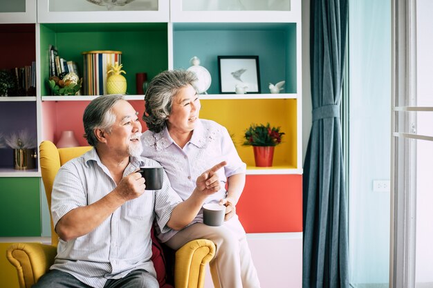 Elderly Couple Talking together and drinking coffee or milk