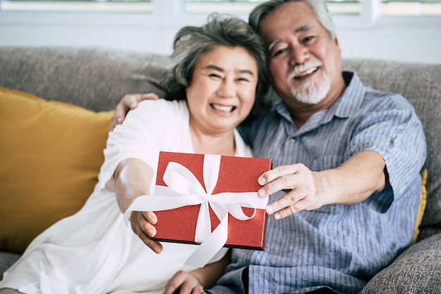 Elderly Couples Surprise and gift box at living room