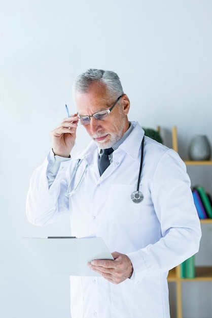 Free Photo elderly doctor reading records