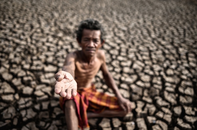 An elderly man was sitting asking for rain in the dry season, global warming