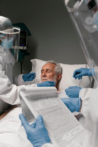 Free photo elderly man with respirator next to doctors