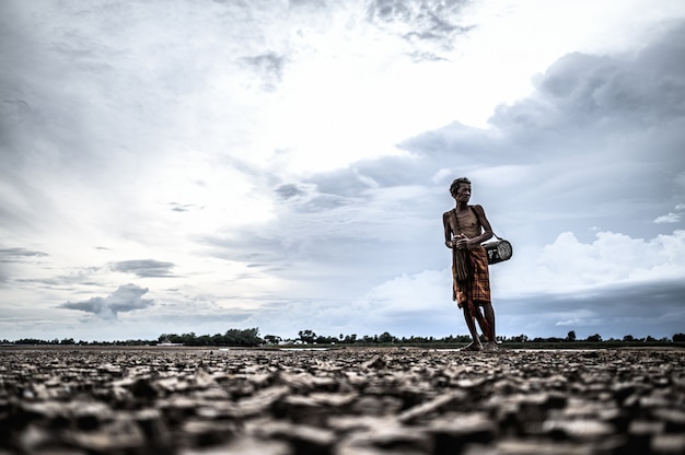 Free photo elderly men find fish on dry ground, global warming