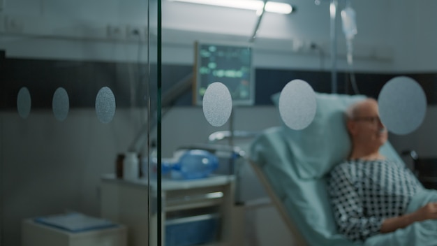 Free photo elderly patient with disease sitting in hospital ward