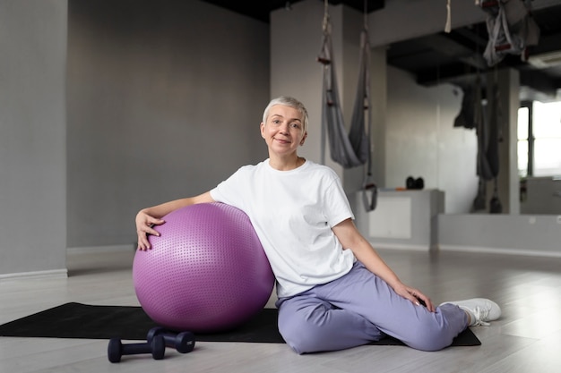 Elderly woman doing a gym ball workout at the gym