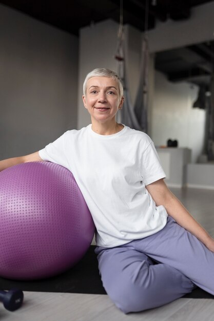 Elderly woman doing a gym ball workout at the gym