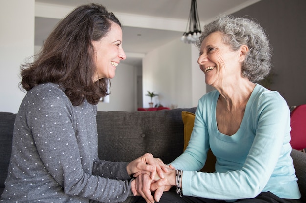 Free photo elderly woman and her daughter laughing and holding hands