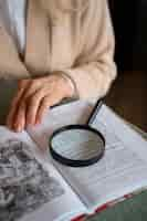 Free photo elderly woman reading while using a magnifying glass