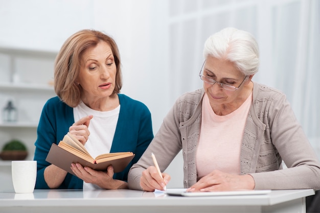 Elderly woman taking notes together