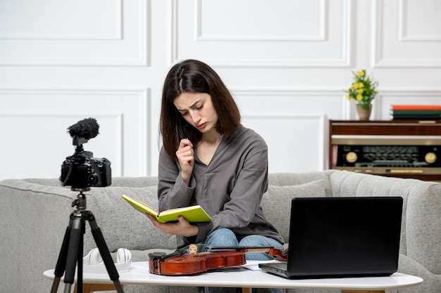 Elearning cute young beautiful girl remotely at home taking violin classes thinking