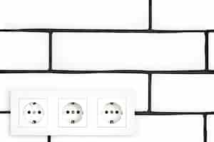 Free photo electrical outlets against a white brick wall.