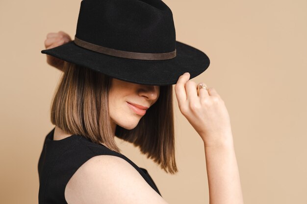 Elegance portrait of a young stylish woman in a black hat