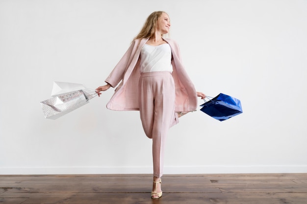 Elegant adult woman posing with shopping bags