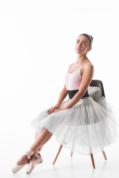 Free photo elegant ballerina sitting on chair daydreaming