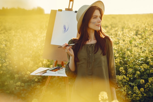 Free Photo elegant and beautiful girl painting in a field