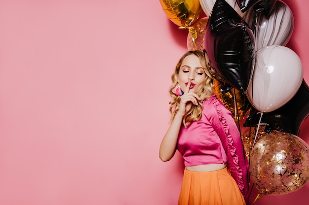 Elegant birthday woman posing on pink wall