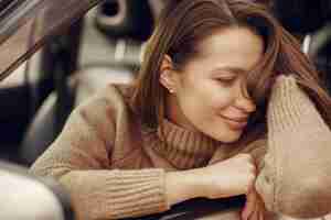 Free photo elegant businesswoman sitting in a car