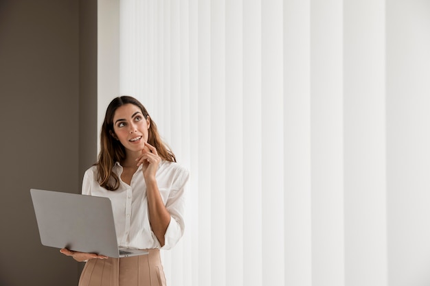 Elegant businesswoman using laptop with copy space