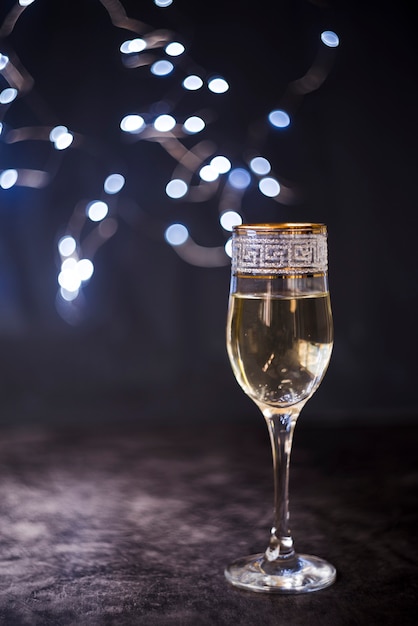 Elegant champagne glass on textured surface at night party