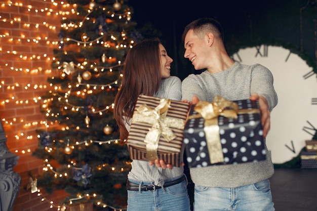 Elegant couple at home near christmas tree