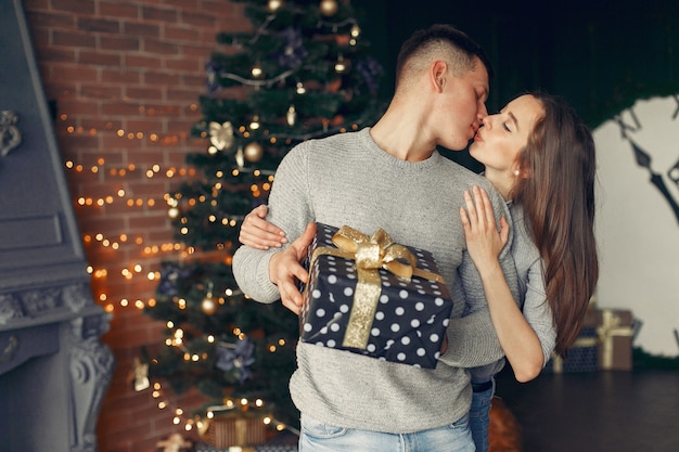 Elegant couple at home near christmas tree