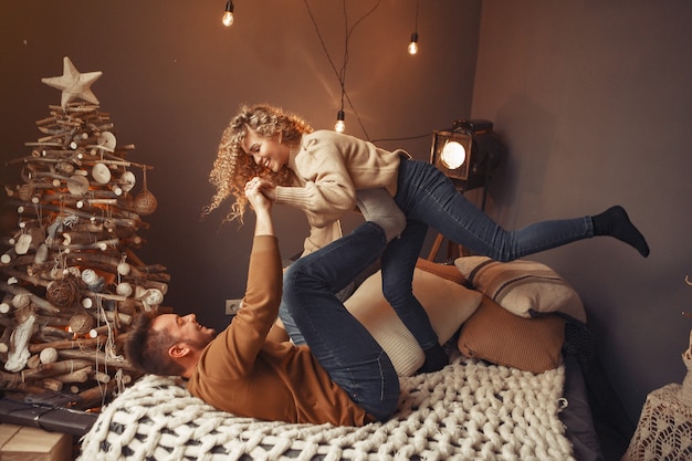 Elegant couple sitting at home near christmas tree