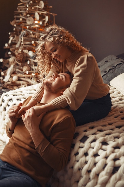 Elegant couple sitting at home near christmas tree