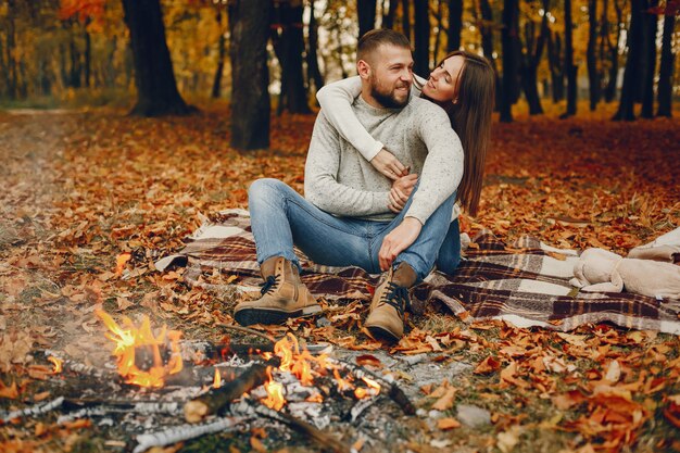 Elegant couple spend time in a autumn park