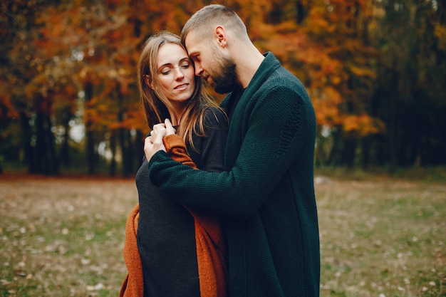 Elegant couple spend time in a autumn park