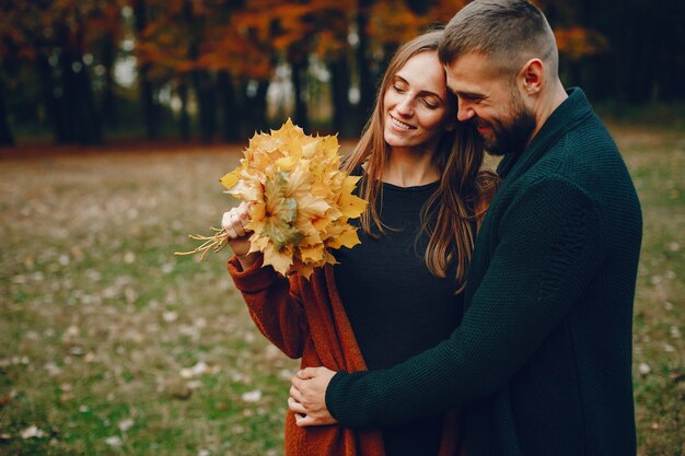 Elegant couple spend time in a autumn park