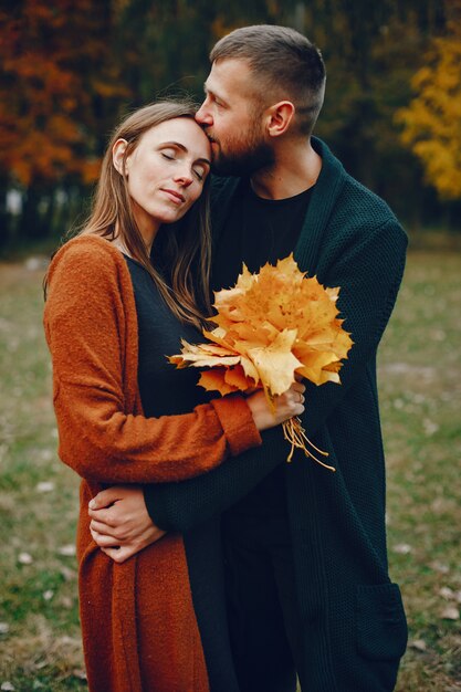 Elegant couple spend time in a autumn park