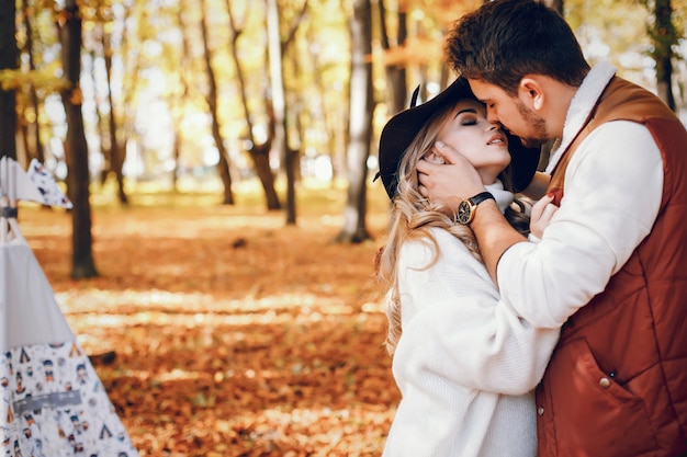 Free photo elegant couple in a sunny autumn park