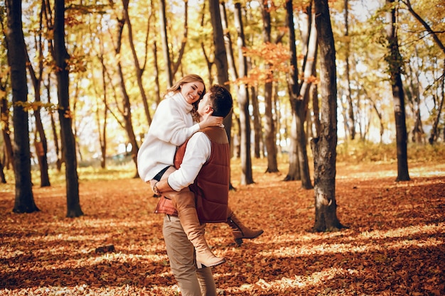 Free photo elegant couple in a sunny autumn park