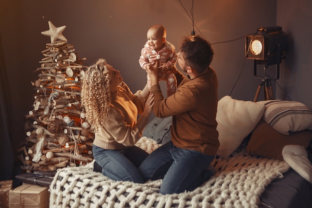 Elegant family sitting at home near christmas tree