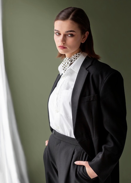 Free photo elegant female model posing in a jacket suit with a tie. new feminity concept