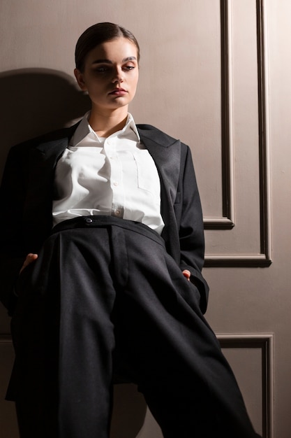 Free photo elegant female model posing in studio in jacket suit. new feminity concept