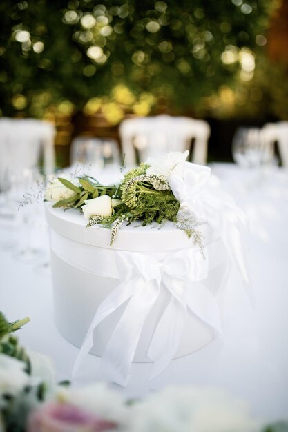 Elegant gift box with white roses on wedding table.