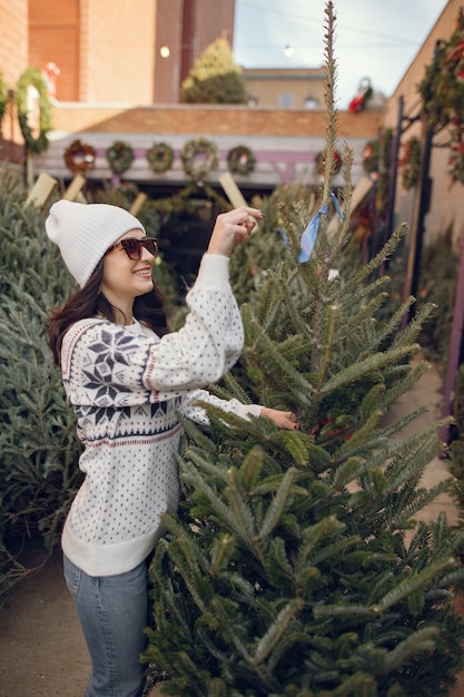 Free photo elegant girl buys a christmas tree.