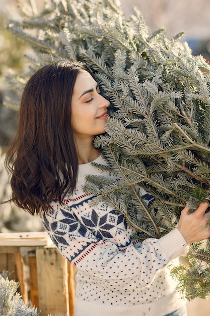 Free photo elegant girl buys a christmas tree.