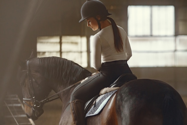 Elegant girl in a farm wiith a horse