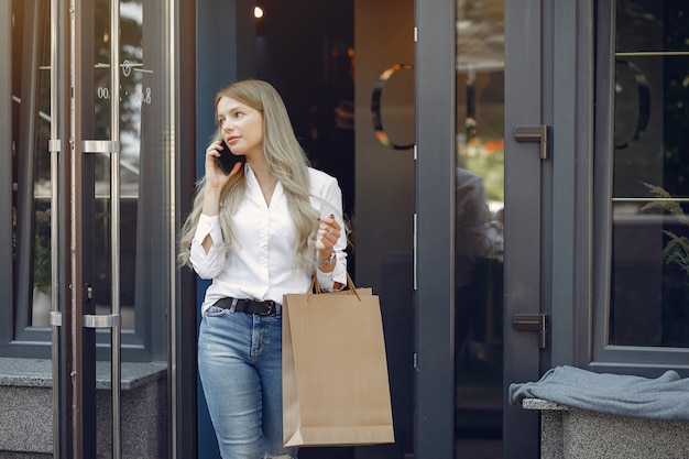 Free photo elegant girl with shopping bag in a city