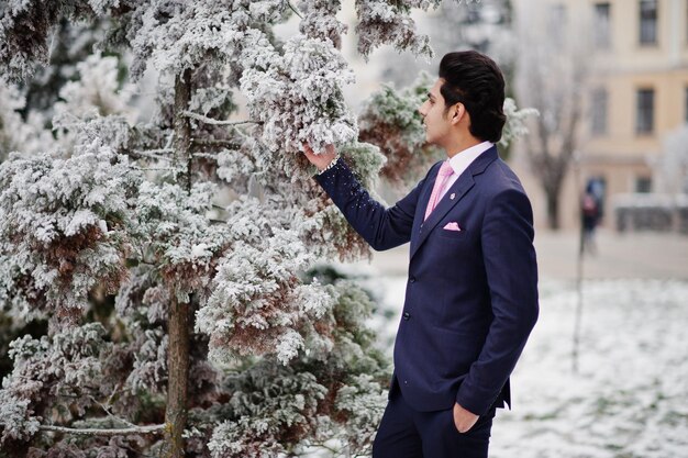 Elegant indian macho man model on suit and pink tie posed on winter day