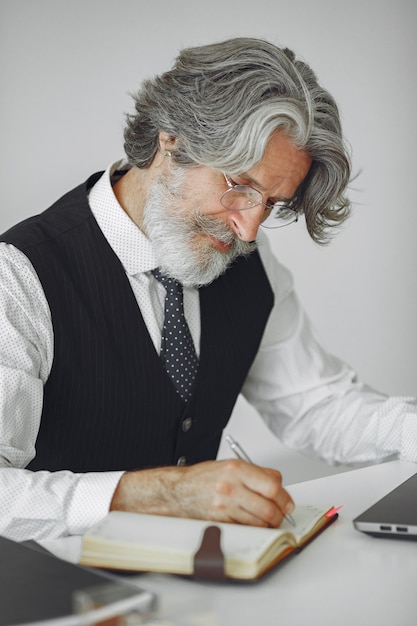 Free photo elegant man in office. businessman in white shirt. man works with laptop.