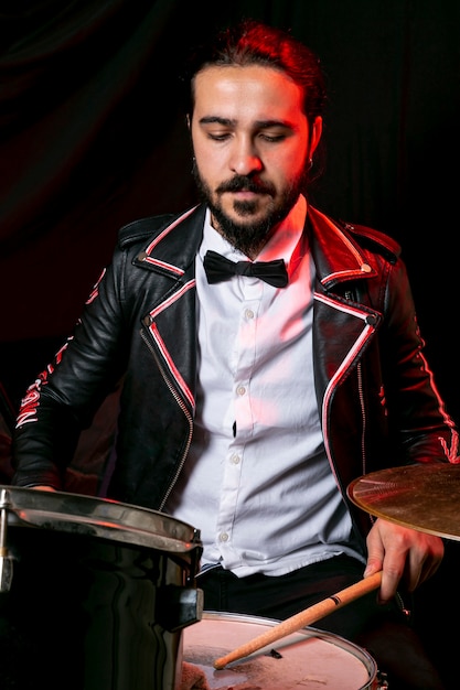 Free photo elegant man playing on drum set