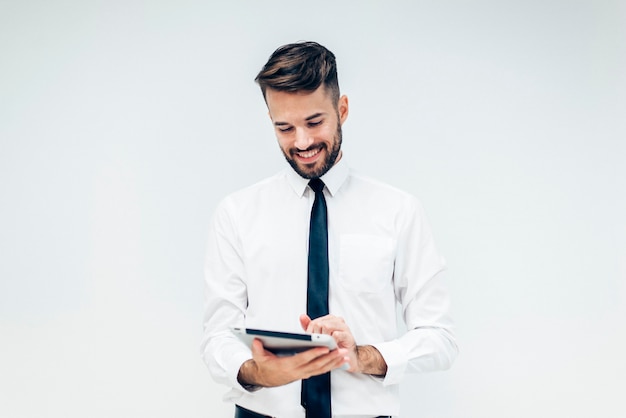 Elegant man smiling while watching a tablet