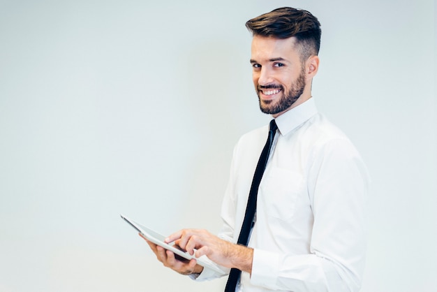 Free photo elegant man smiling while watching a tablet