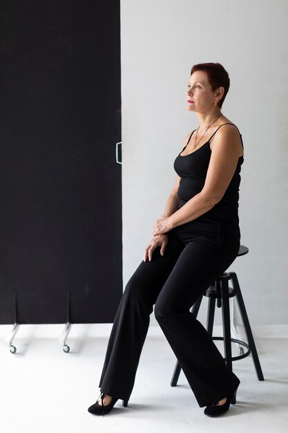 Elegant mature woman sitting on a stool