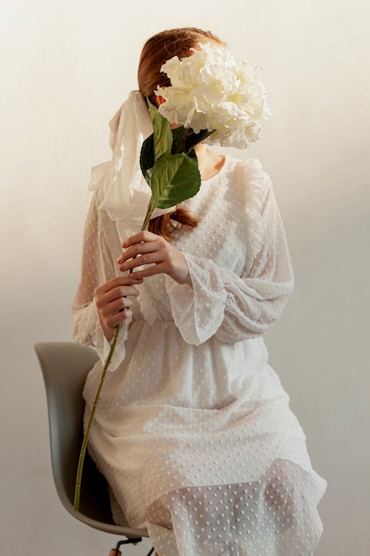 Elegant model holding flowers medium shot