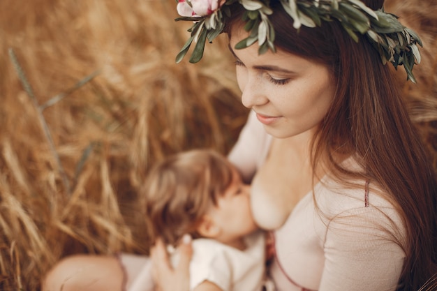 Elegant mother with cute little daughter in a field